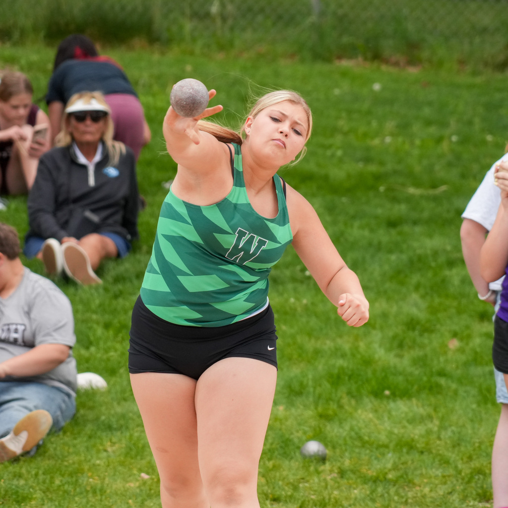 A Wahlquist girl's track athlete throws the shotput towards the camera