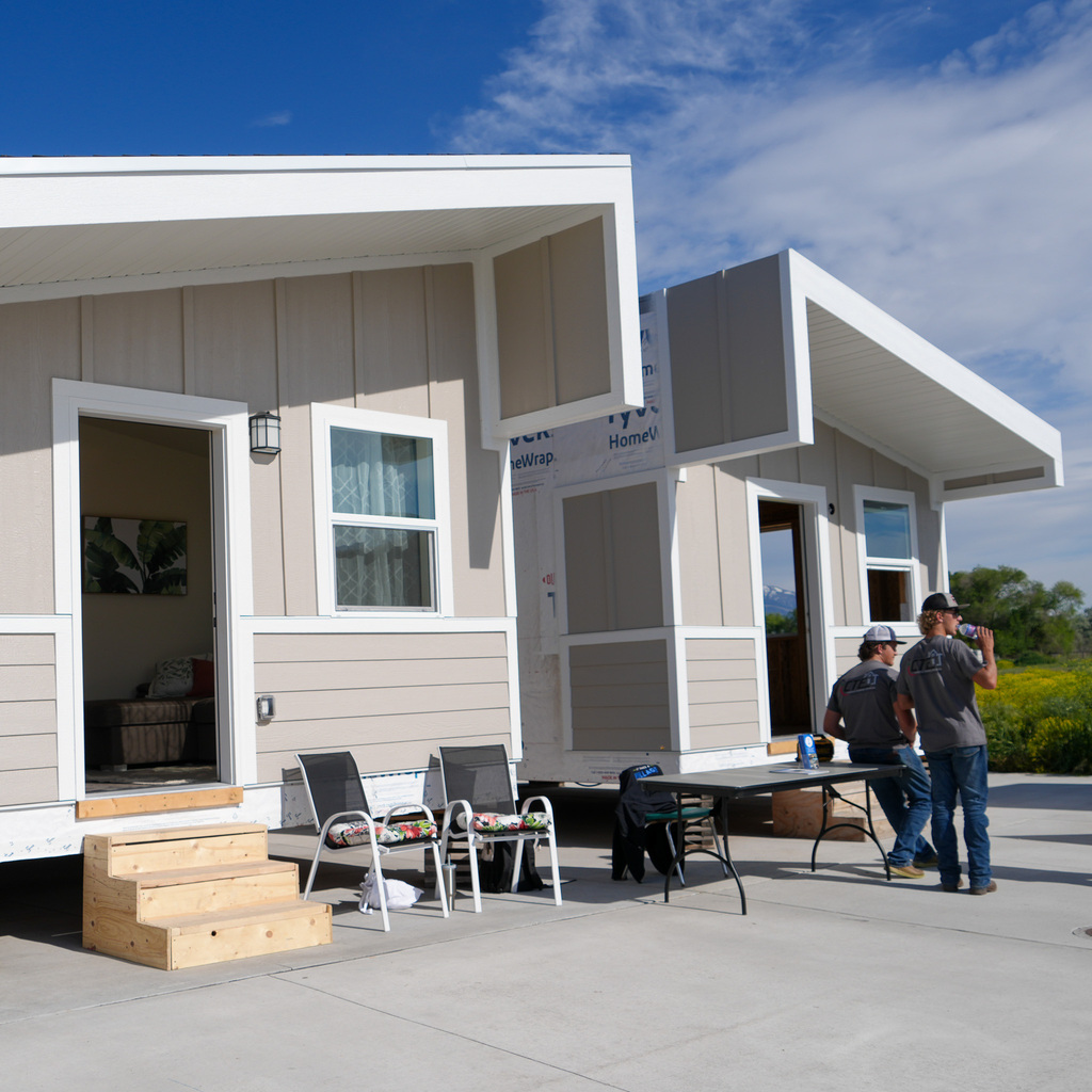 Two students stand in front of the tiny homes