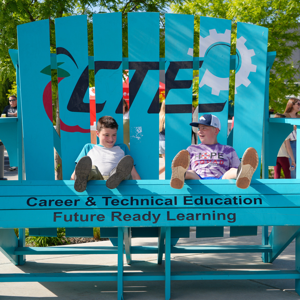 Two young boys sitting in an oversized chair with the cte logo