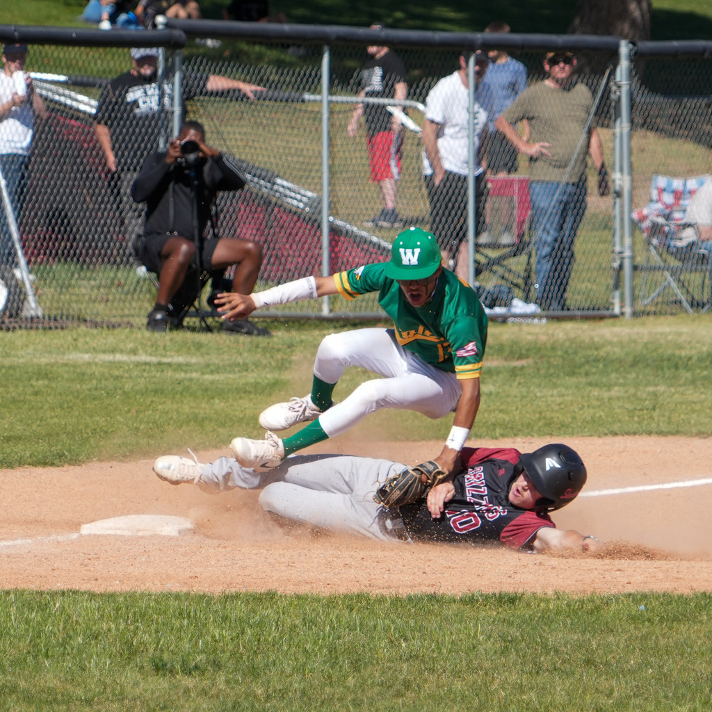 A rocky mountain player slides into base with wahlquist player tagging him