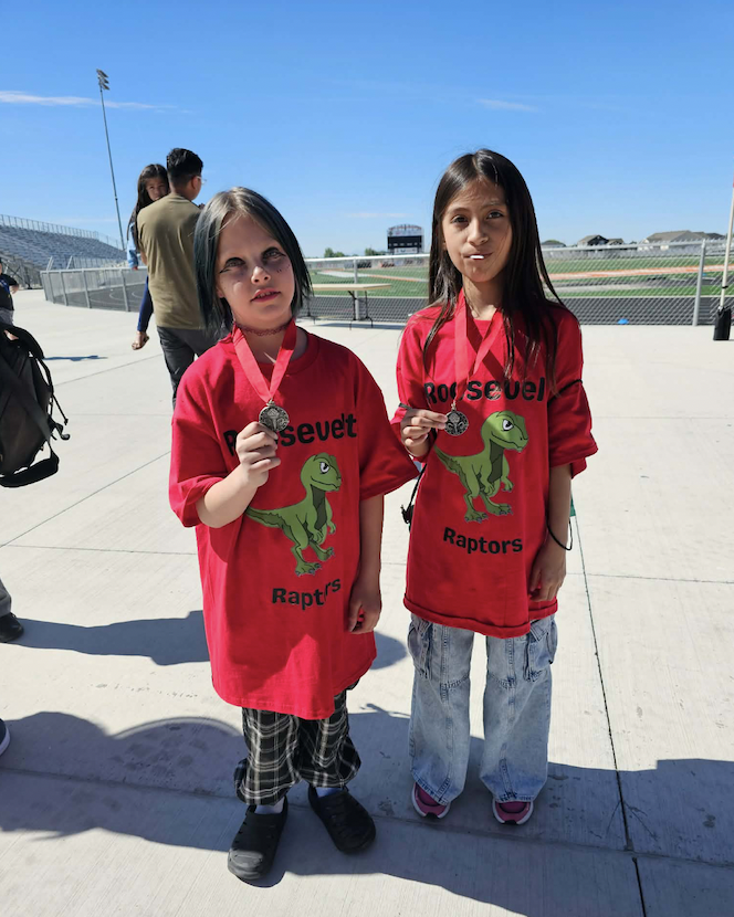 two 3rd grade students holding their medals