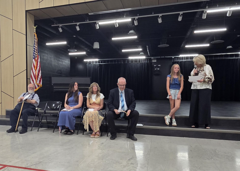School principal reading about a graduating 6th grade student