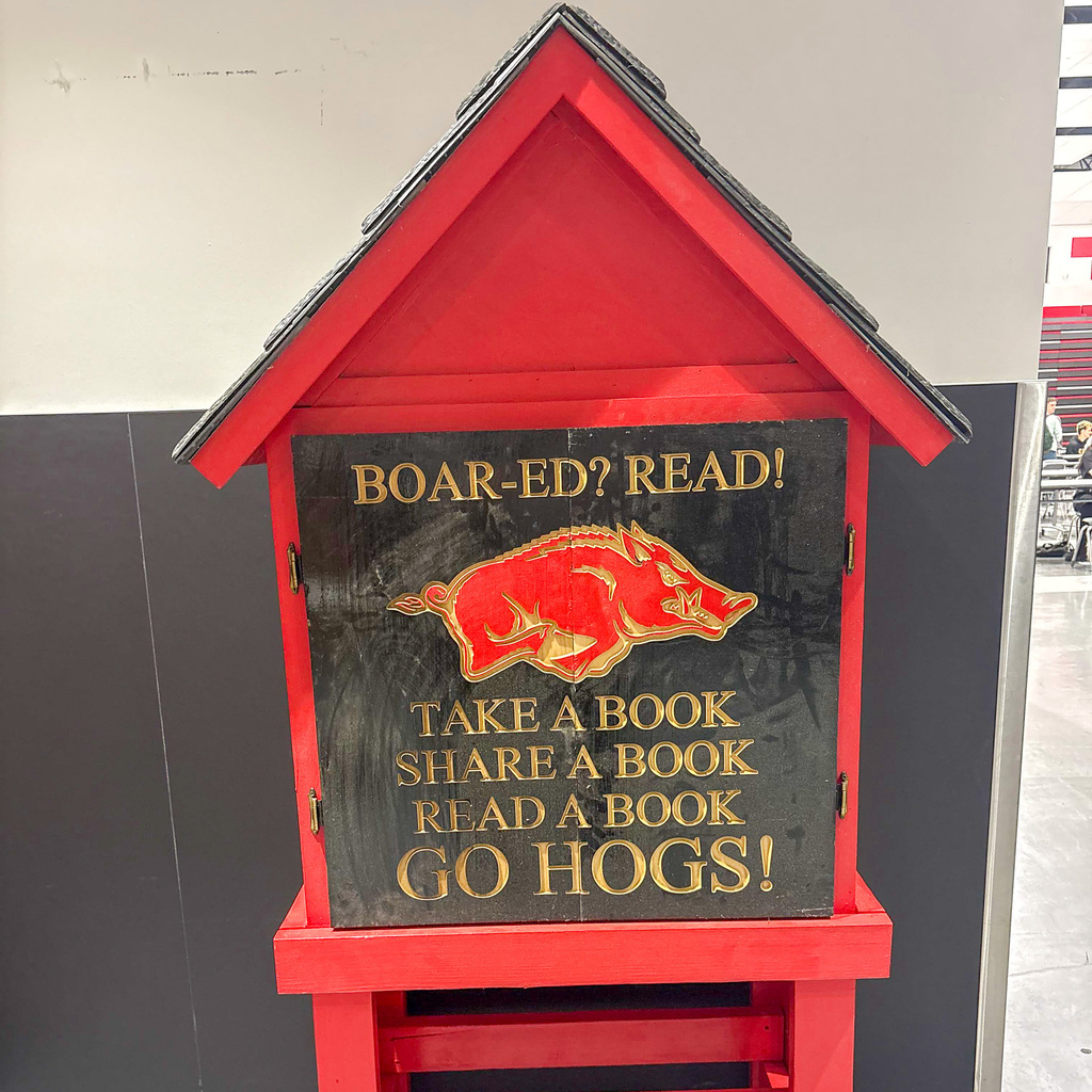 A tiny library sits in a hallway with the words Boar-ed? Read! Go Hogs at Roy Junior High
