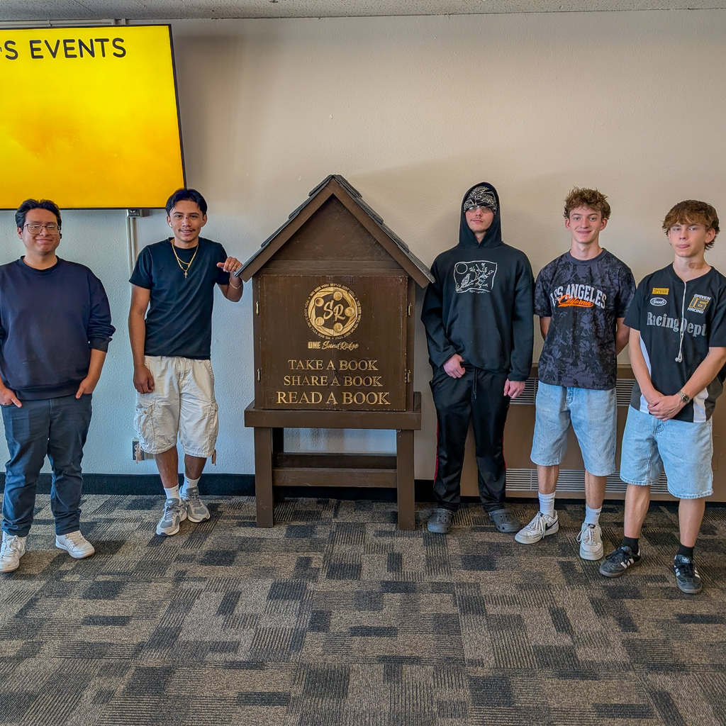 Students are standing next to a completed tiny library at Sand Ridge Junior High