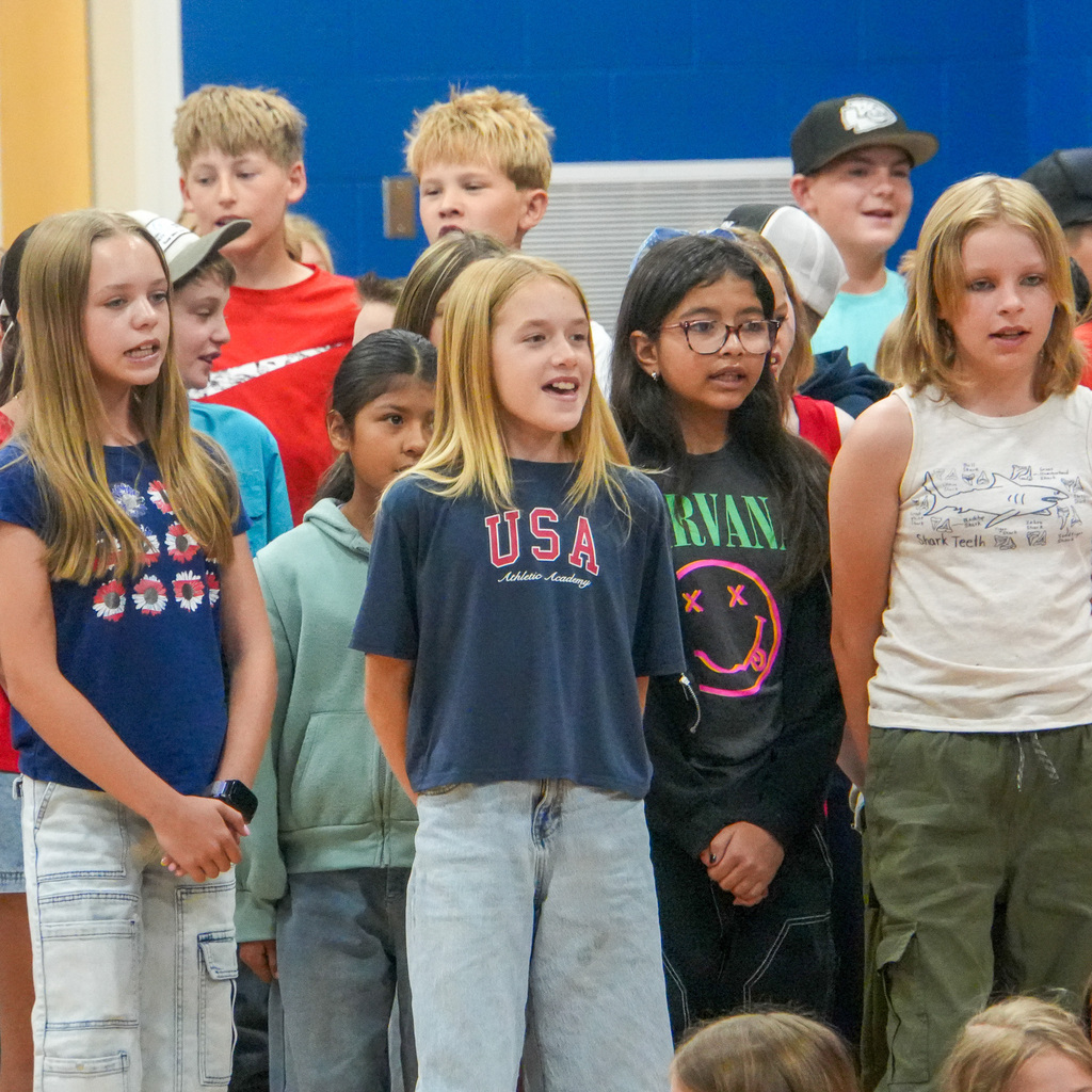 Students standing and singing in an school assembly