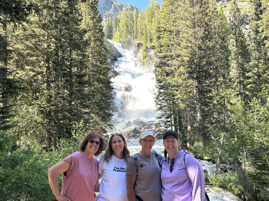 4 people standing in front of a water fall
