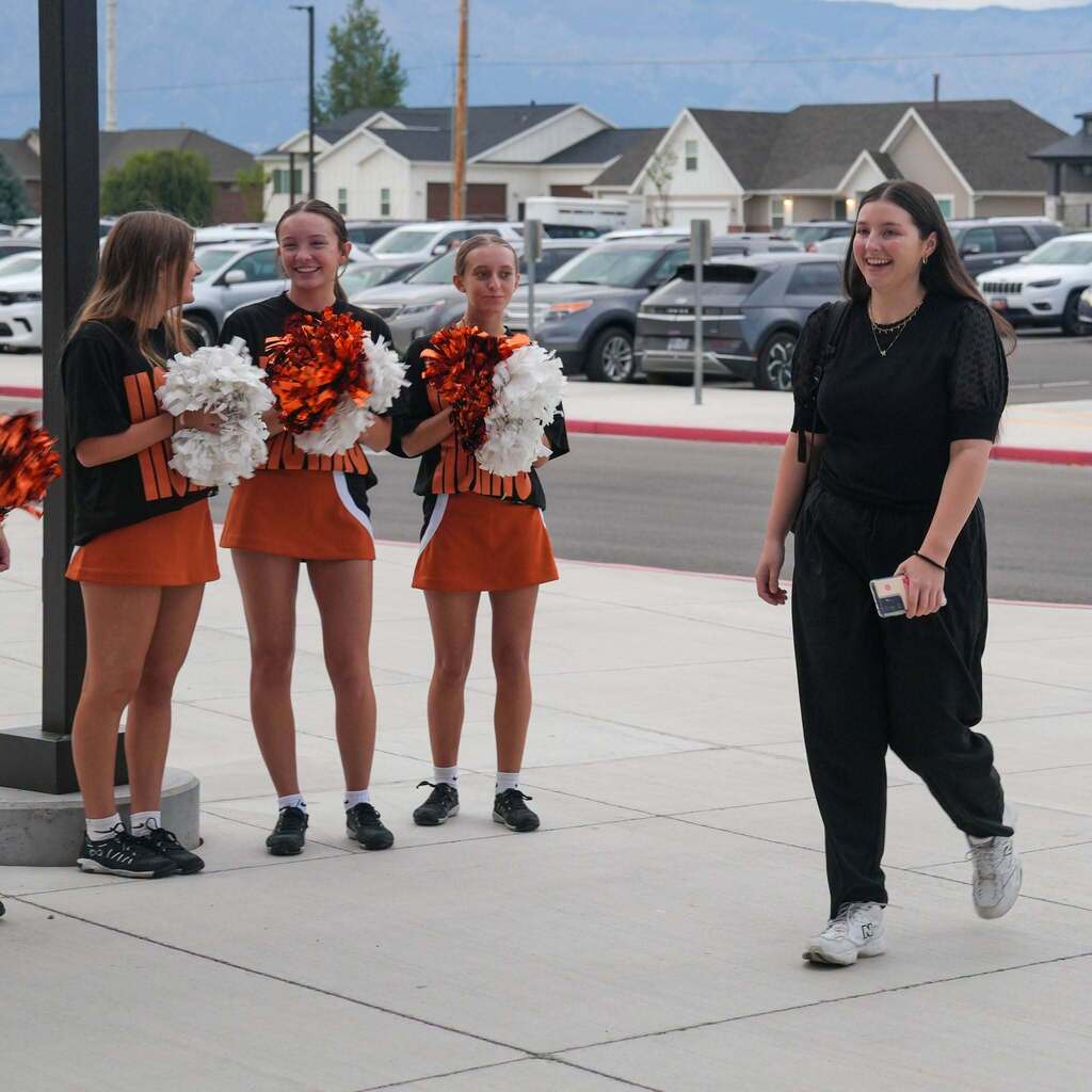 new teachers walking past cheerleaders