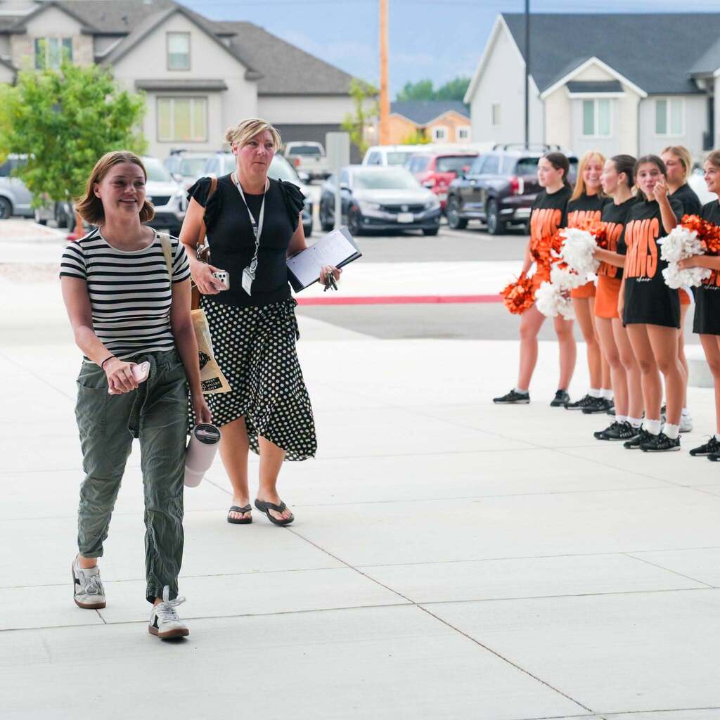 new teachers walking past cheerleaders