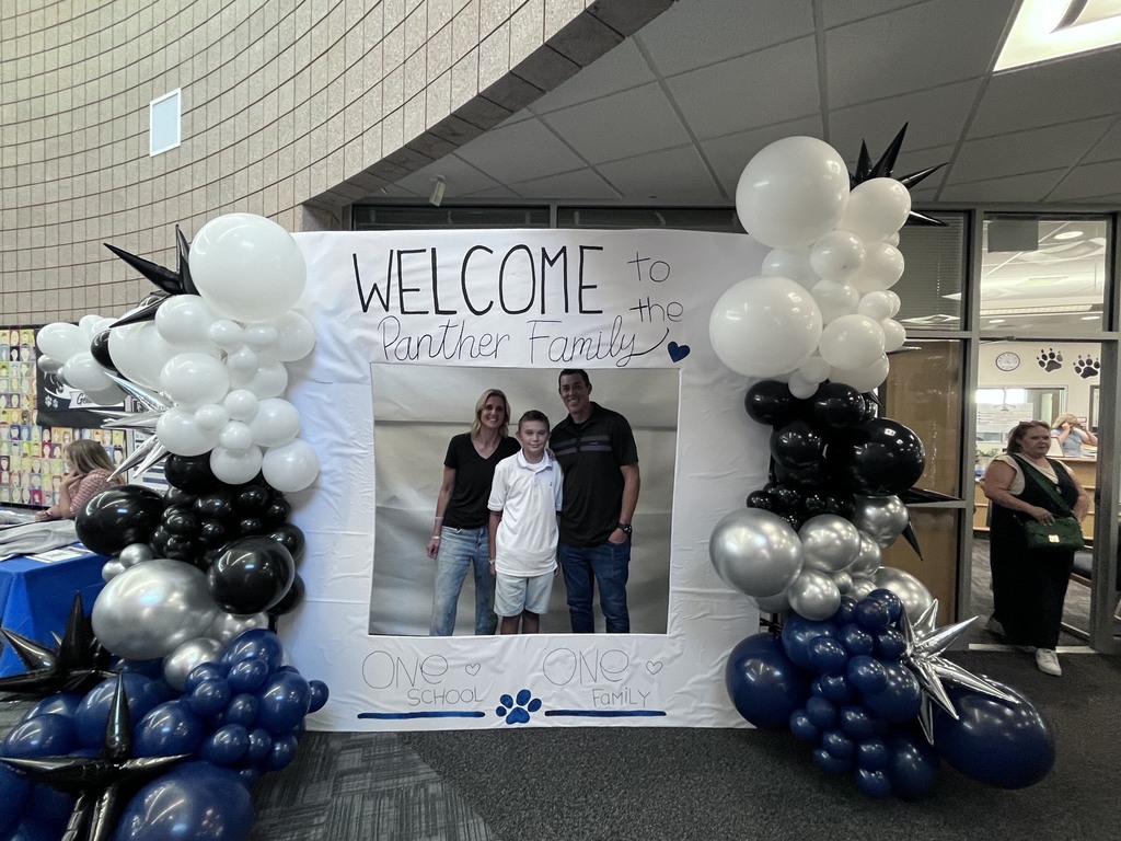 students in a photo booth that reads: welcome to the panther family, one school, one family