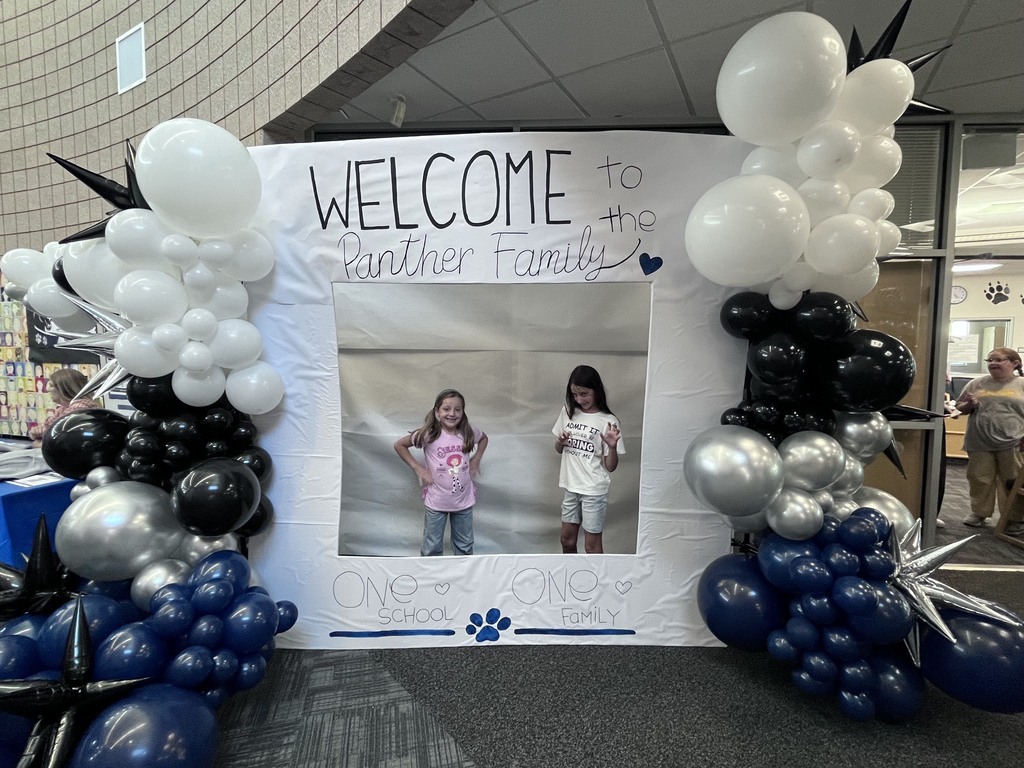 students in a photo booth that reads: welcome to the panther family, one school, one family