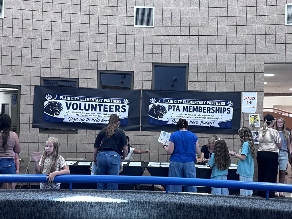 the backs of students and parents heads, looking at volunteers and pta membership sign ups