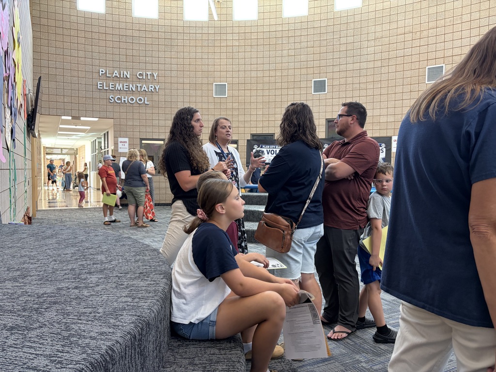parents and students talking to staff in the hallways