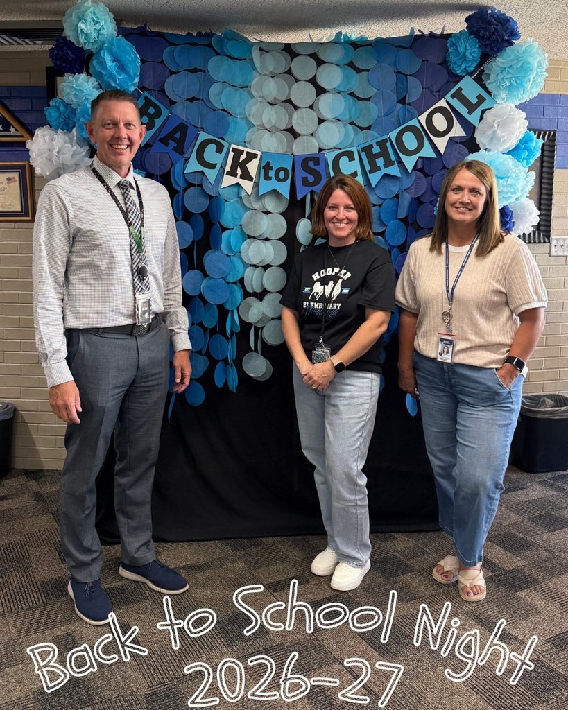 Three Hooper Elementary staff members smile for a photo in front of a blue-and-teal Back to School Night display. Text on the image reads, “Back to School Night 2026–27.”