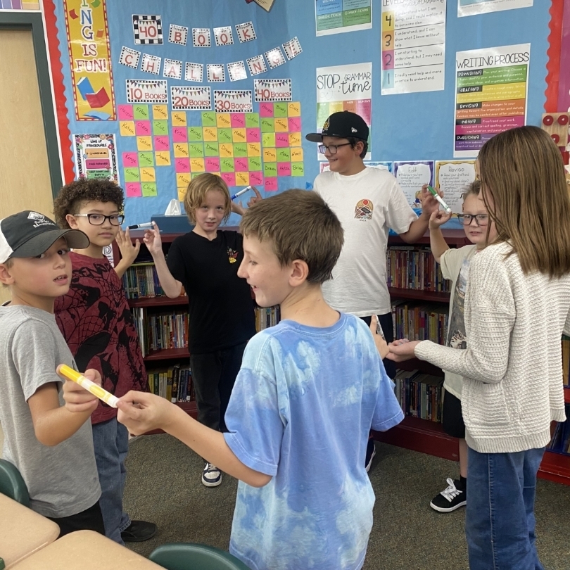 kids in a circle holding markers