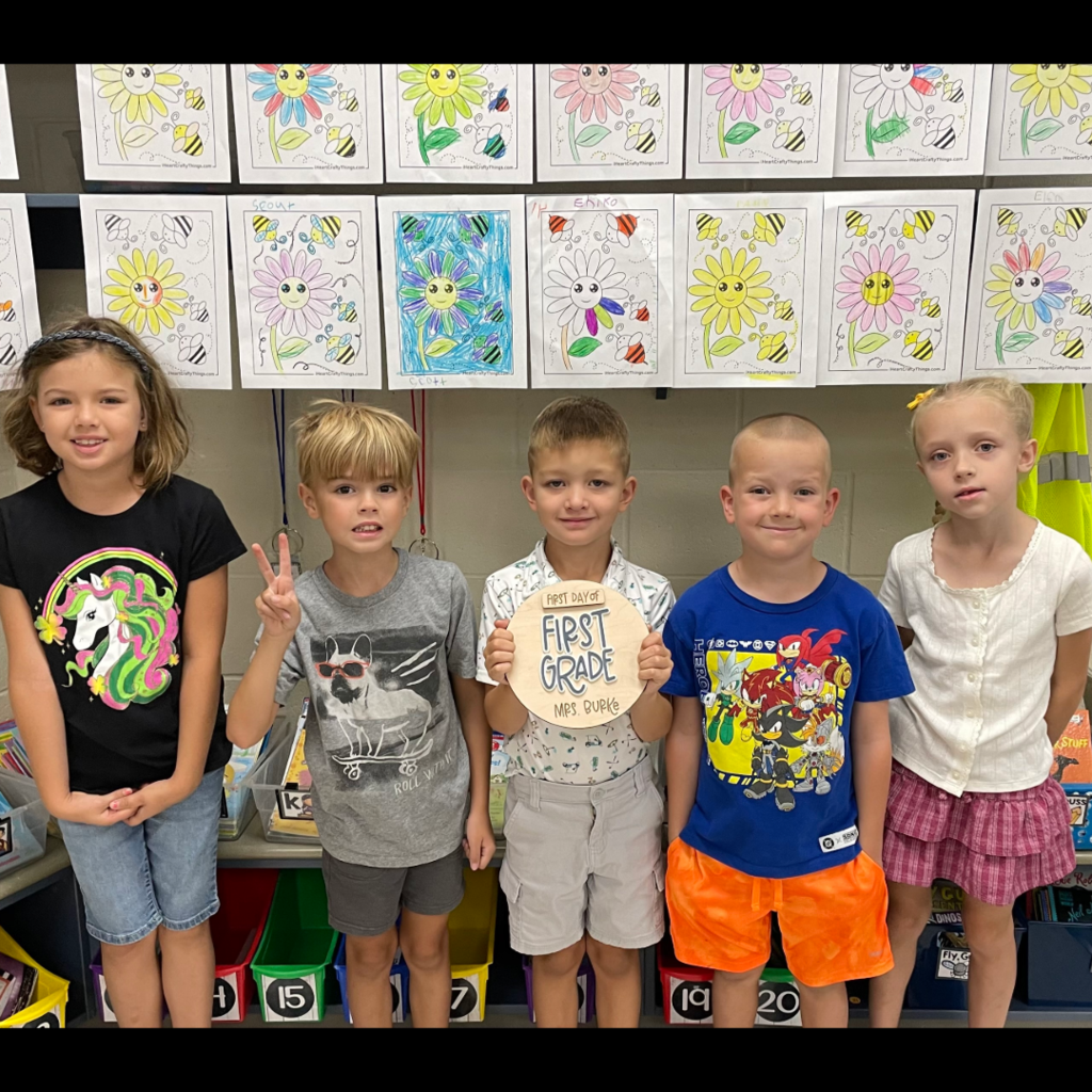 Five students standing in a row.