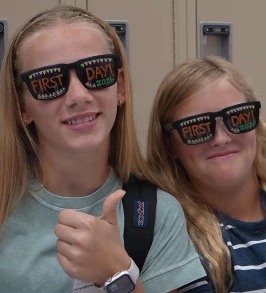 Two girls wearing sunglasses that say 1st day on them.