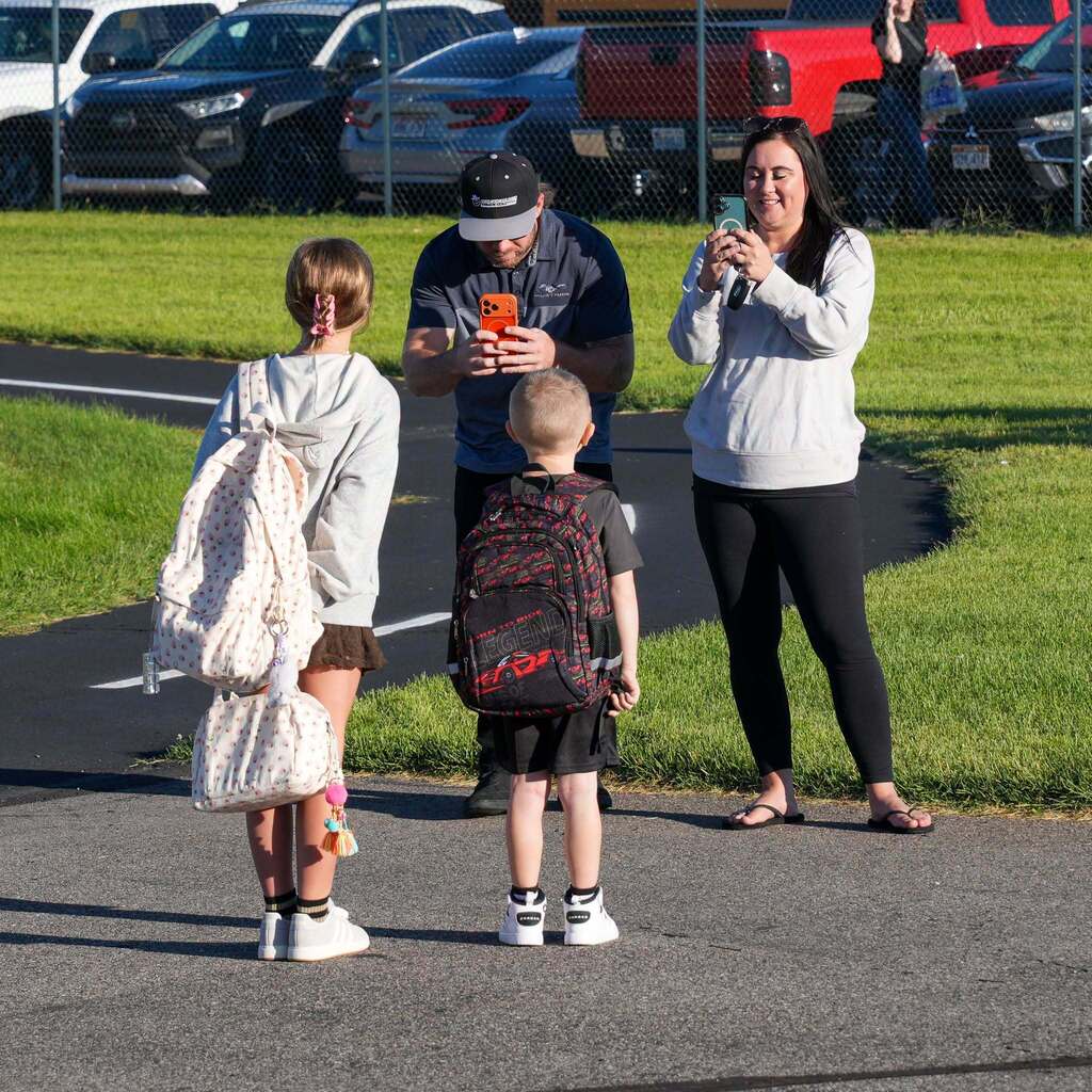 Parents taking pictures of children on the first day.