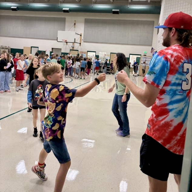 Ogden Raptor team member giving a fist bump to a boy.