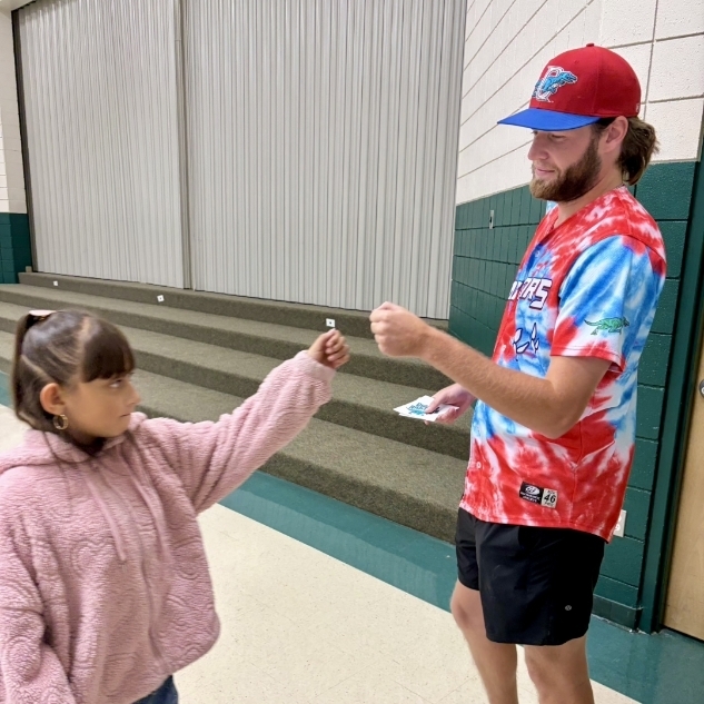 Ogden Raptor team member giving a girl a fist bump