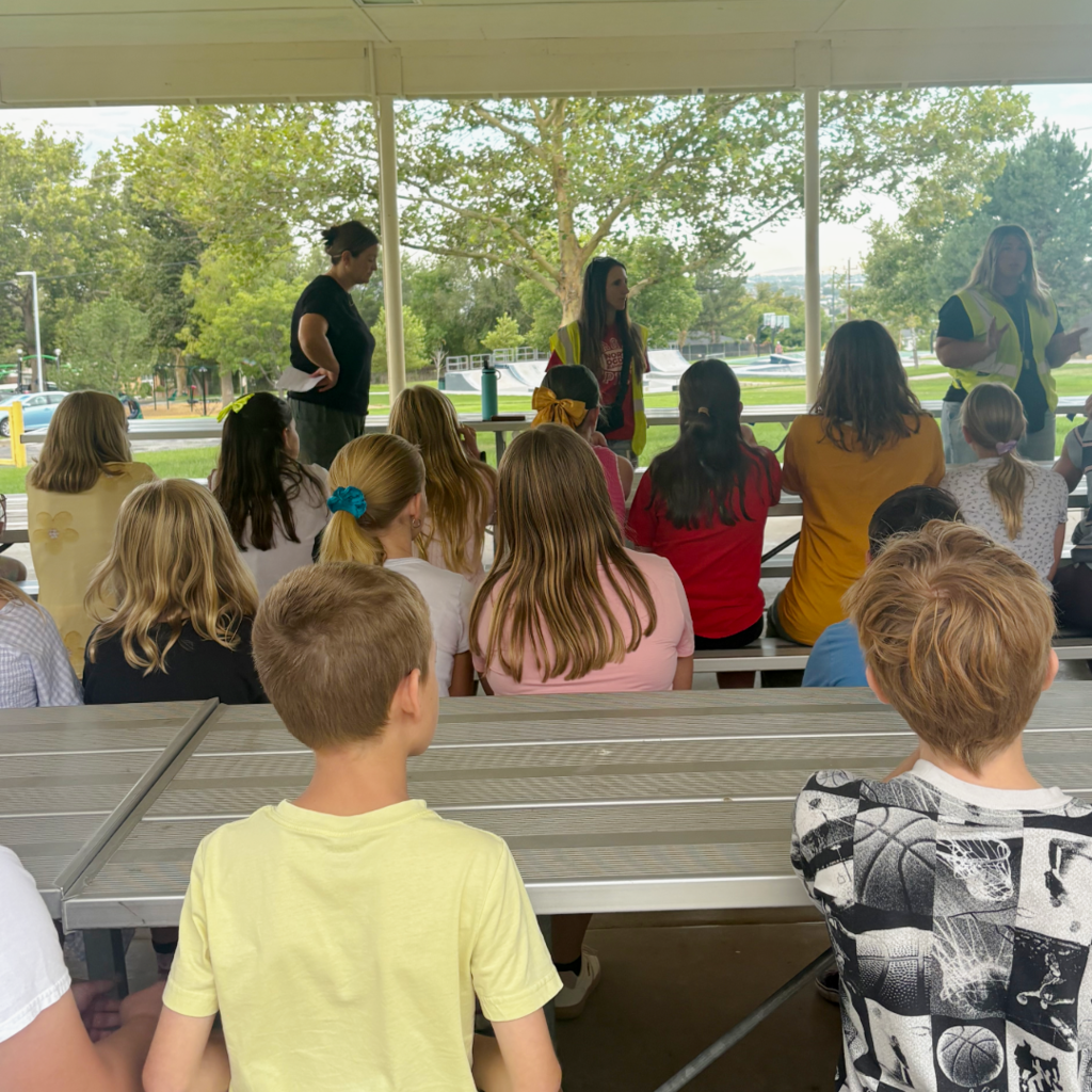 Students sitting on the benches listening to the rules and procedures of the school.