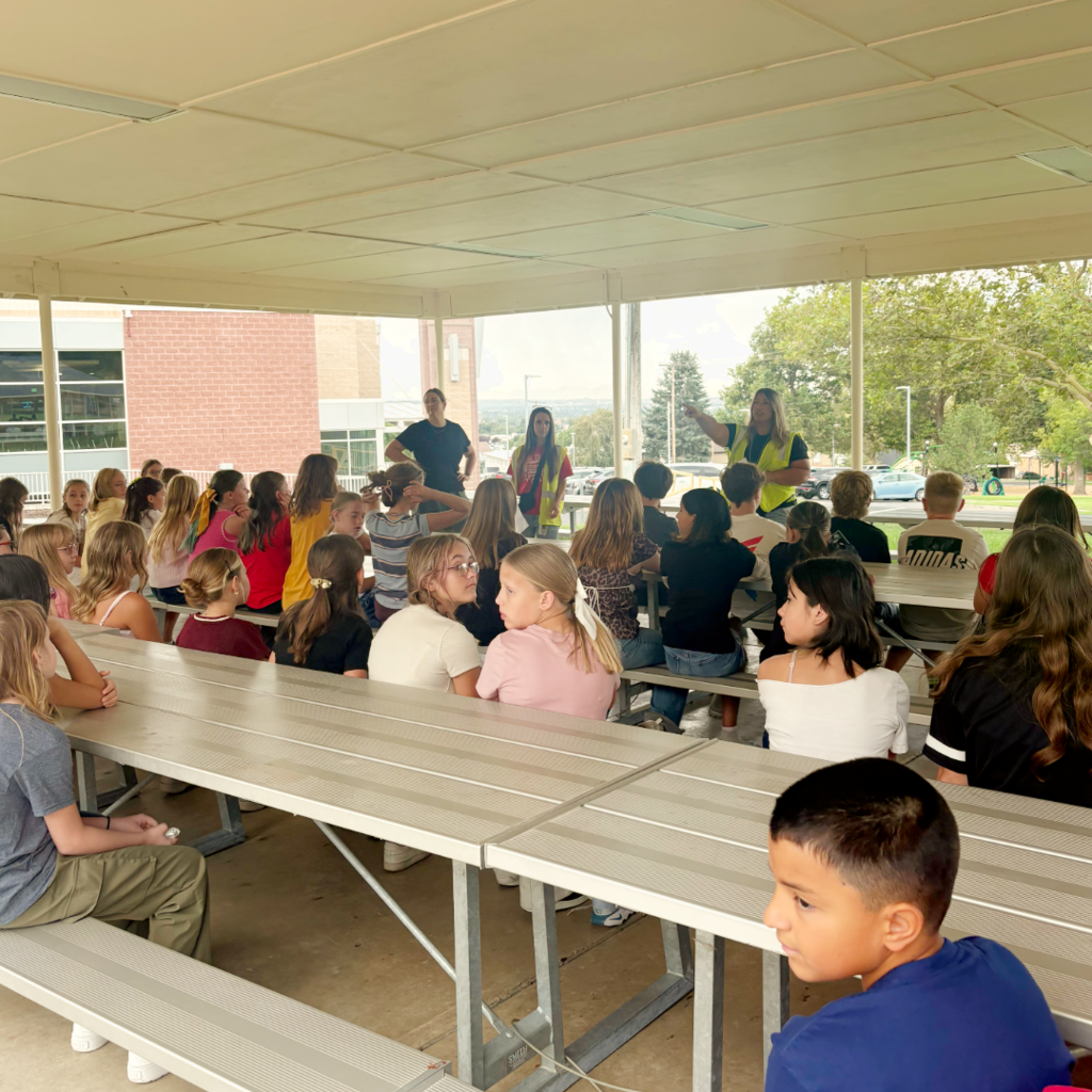 Students sitting on the benches listening to the rules and procedures of the school.