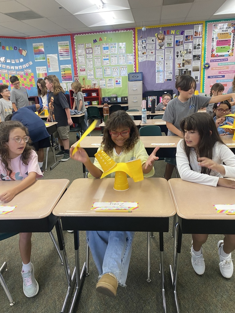 girls doing an experiment with cups and paper