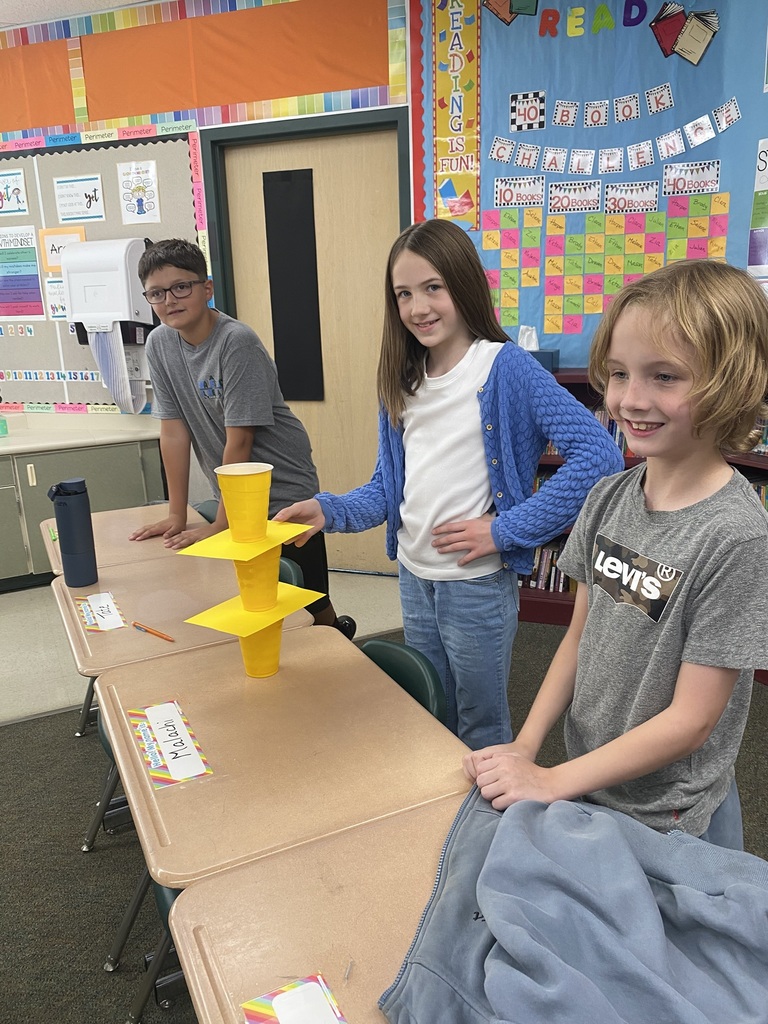 Kids doing an experiment with cups and paper