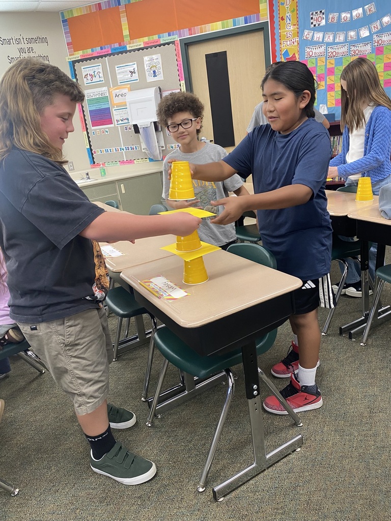 Kids doing an experiment with cups and paper