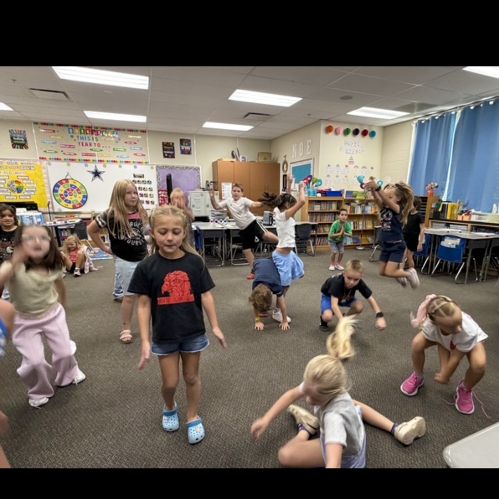 A class of students dancing in their classroom.