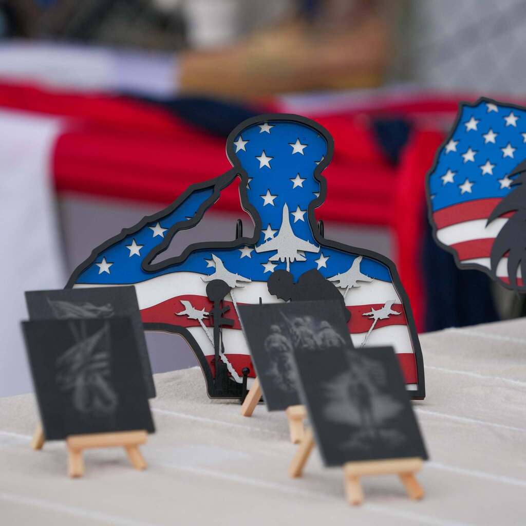 Wooden patriotic tabletop art piece featuring a saluting soldier silhouette decorated with the American flag.