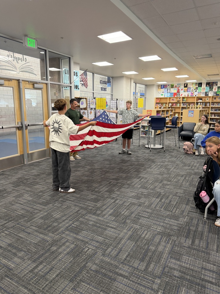 firefighter and students holding flag