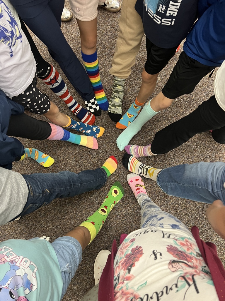image of students with their shoes off putting their feet in a circle