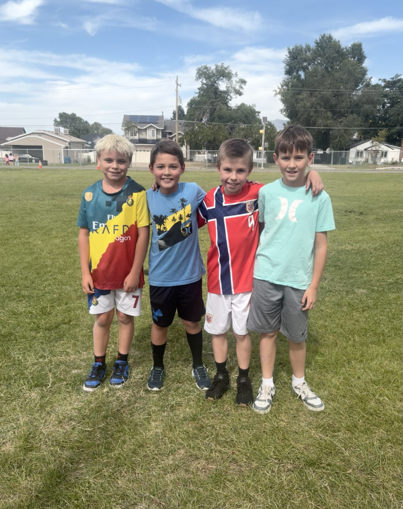 4 boys standing in a field smiling