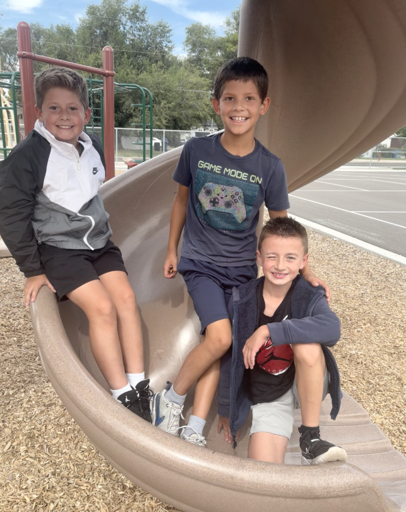 3 boys posing on a slide