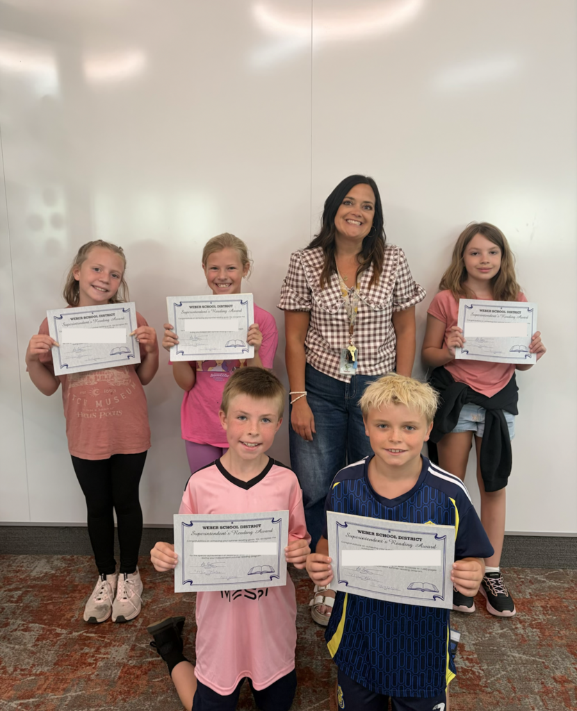 5 students holding awards and posing with their teacher