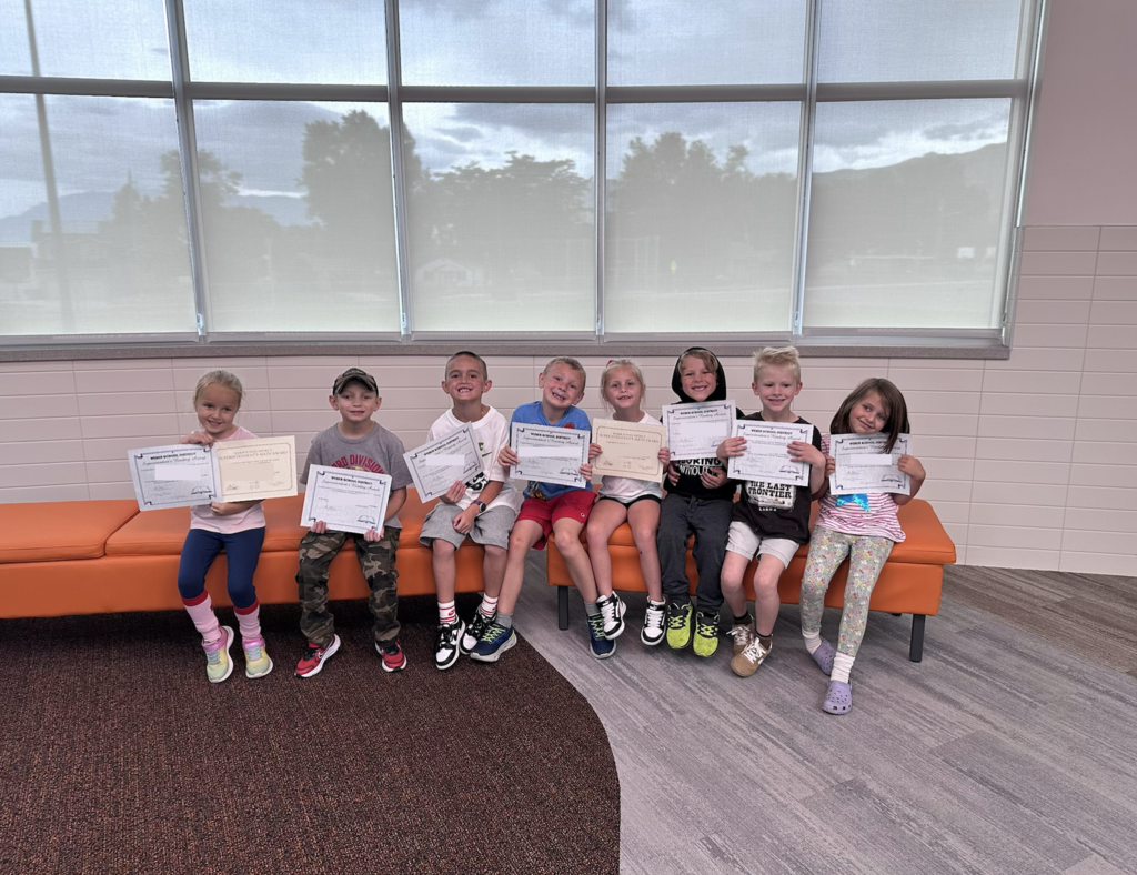 a groud of 1st grade students holding their awards