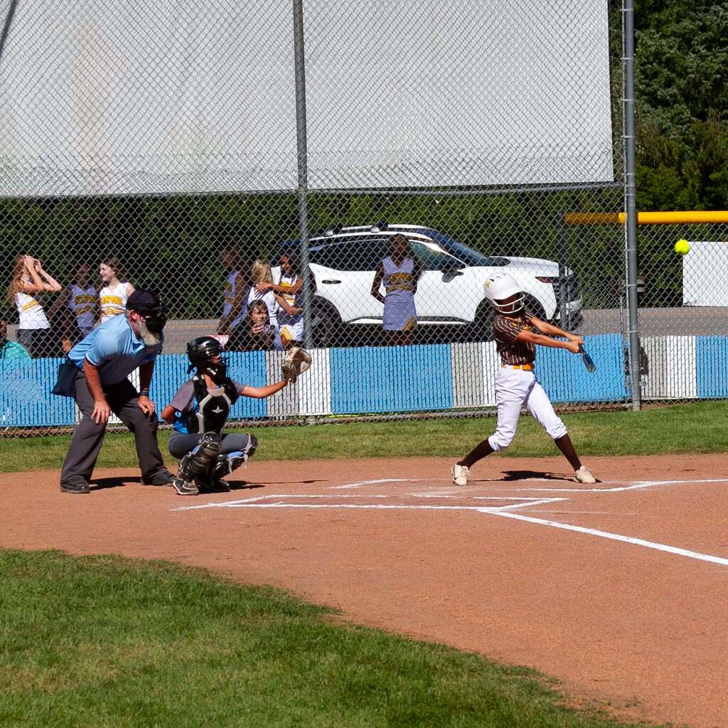 A Sand Ridge batter completes her swing after making contact with a pitch during the softball matchup against Snowcrest.