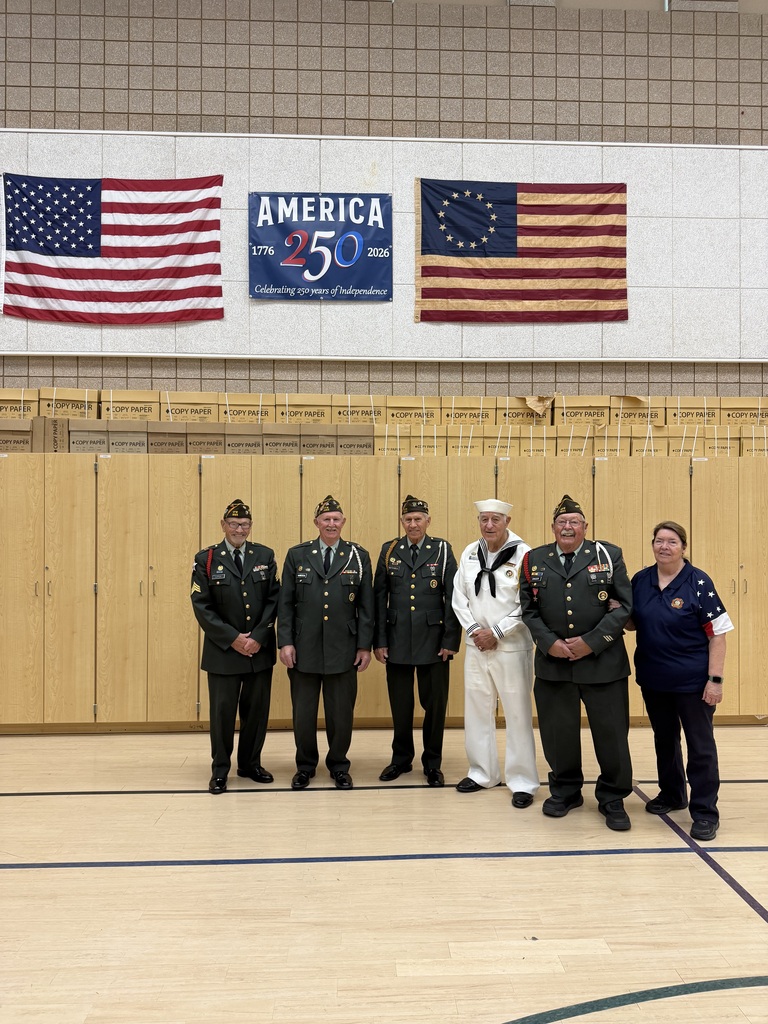 veteran volunteers standing in front of the american flag, america 250 flag smiling