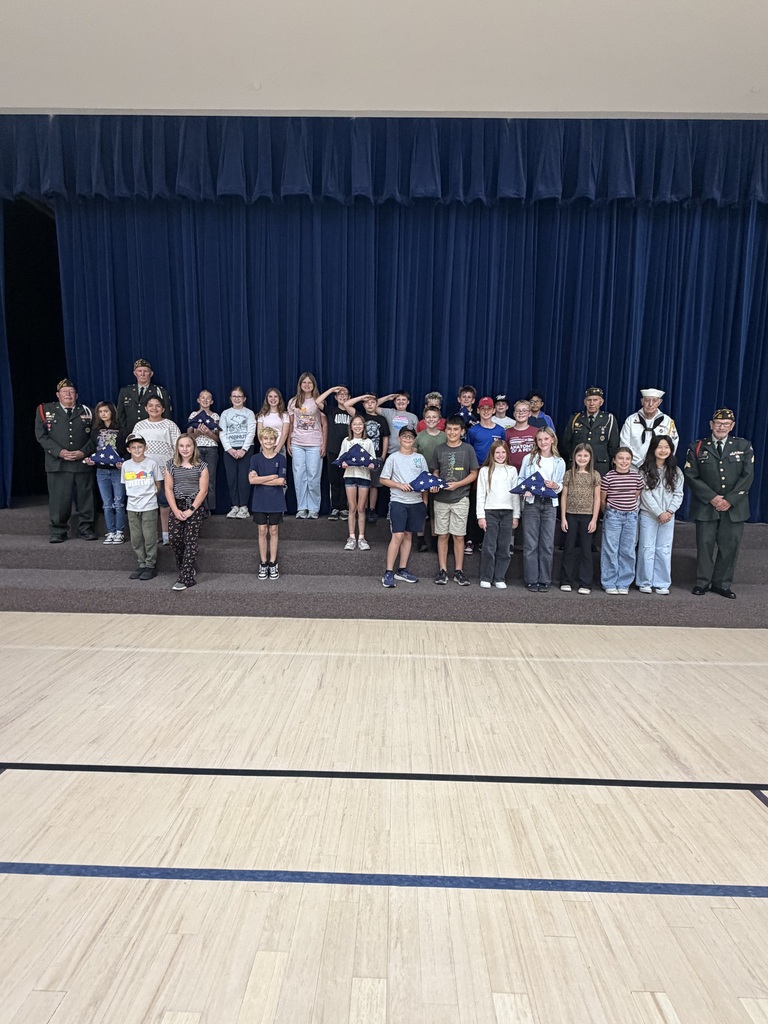 students smiling holding the american flag folded with veterans 
