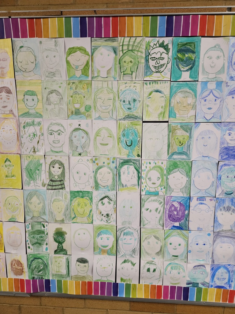 Close-up section of the bulletin board displaying self-portraits drawn in shades of green and teal.
