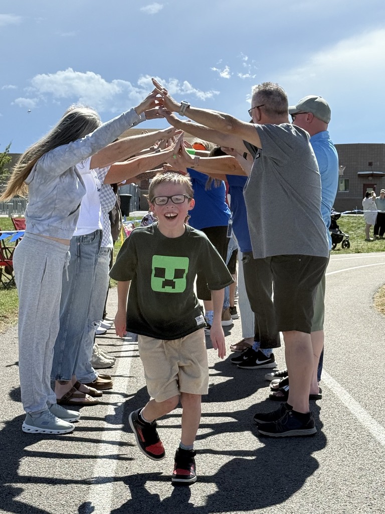 male student running under volunteers/parents/adults hands