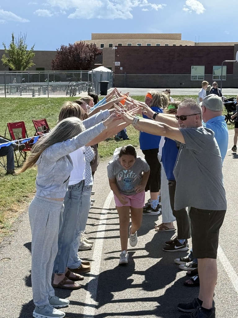 female student running under volunteers/parents/adults hands 