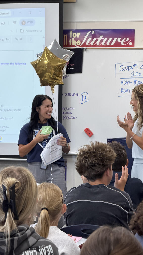 Teacher accepting award in front of class