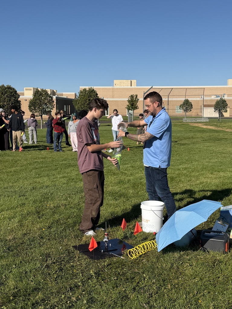 Kid and teacher with home-made rocket