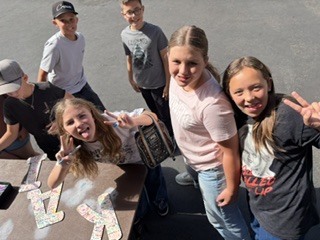 group of students smiling and signing the letters KAIZEN