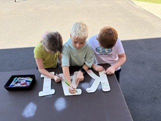 students signing their name on letters KAI