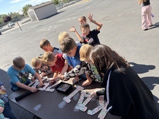 group of students smiling and signing the letters KAIZEN