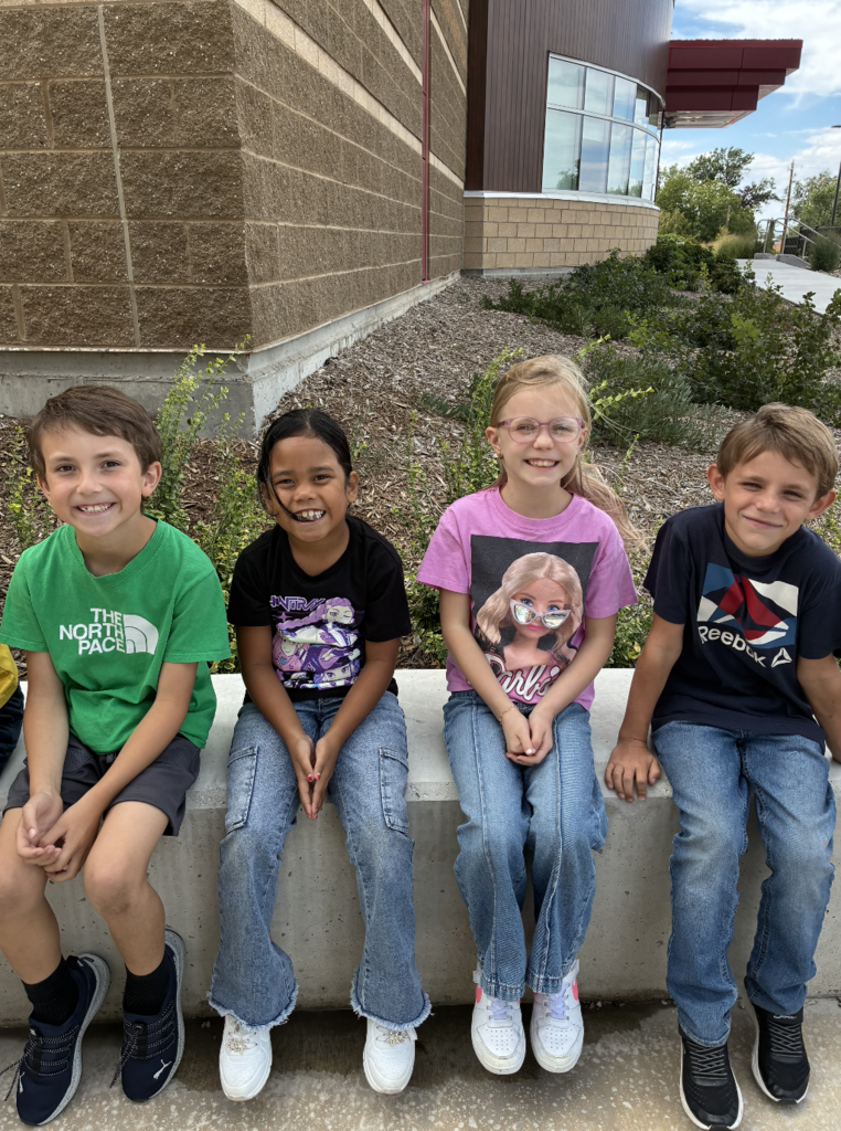 4 kids sitting on the bench outside