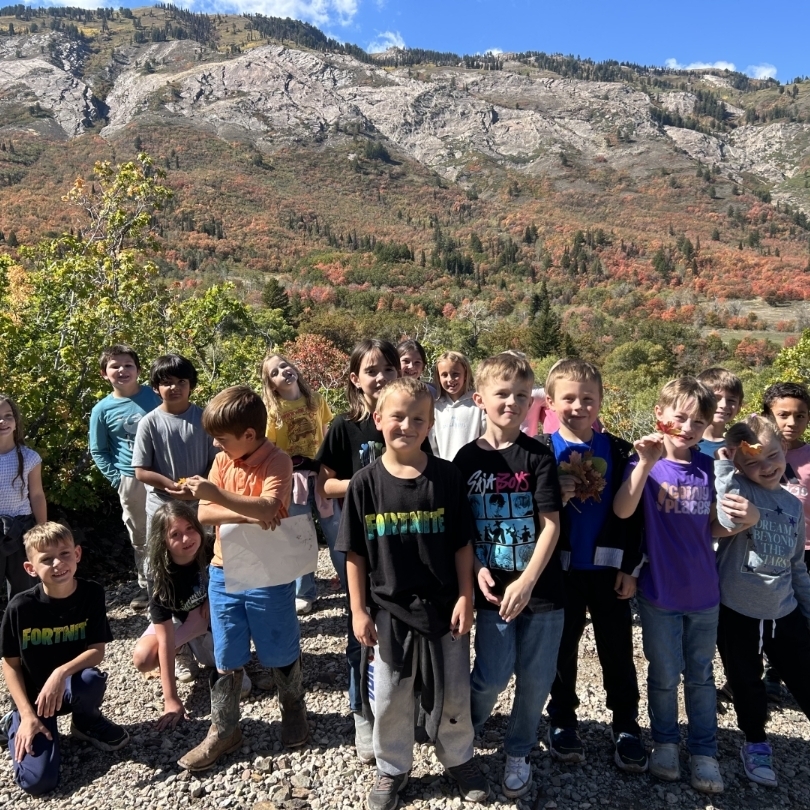 kids posing in front of a mountain with colorful fall foilage