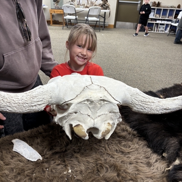 girl posing in front of an ox skull